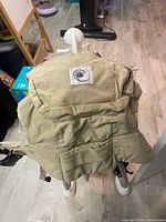 Front view of khaki Ergobaby carrier showing logo and body panel
