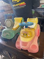 Front view pink car and green digger ride-ons