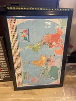 Front view of framed world map showing map detail and dimensions tape
