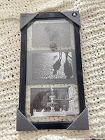 Front of sealed Hometrends black 3-photo frame with corner protectors