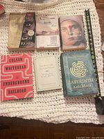Front covers of all six books displayed on crocheted blanket