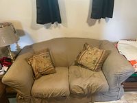 front view of loveseat with slipcover and pillows