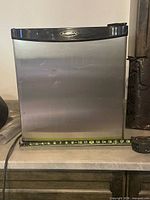 Front view of Simplicity mini fridge showing stainless-look door and dent