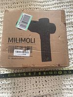 Front of box showing Milimoli branding and silhouette of massage gun