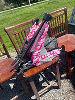 Folded pink floral playpen on chairs showing frame and fabric