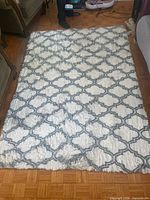 Full view of cream shag rug with grey lattice pattern
