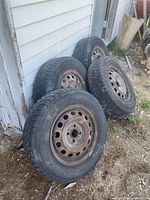 Four tires leaning against exterior wall