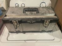 Closed toolbox front view showing stainless panels, latches, and handle
