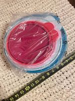 Factory-sealed stack of nested bowls showing outer blue piece and nested colors