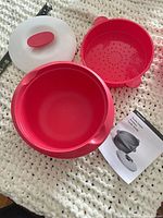 Set disassembled showing base bowl, vented tray, lid and manual with tape measure nearby