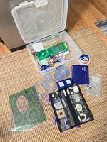 Overall lot layout showing storage box, templates, punch tool, ribbon, tubing, organizer and other supplies