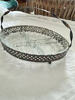 Angle view showing glass dish in pierced metal frame with handle raised