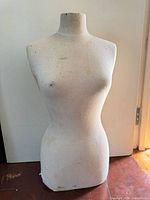 Front view of fabric-covered female torso form showing stains
