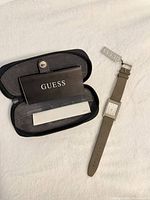 Watch, strap, case interior with paperwork and hang tag