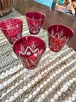 Four ruby red cut glass wine glasses on table