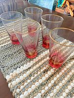 Five pink ombre honeycomb tumblers on woven mat