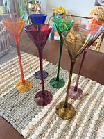 All six coloured cordial glasses standing on table runner