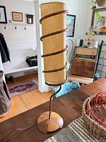 Full view of lamp on table showing wood base, spiral stem, and fiberglass shade