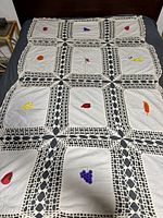 Full view of bedspread laid on bed showing crochet grid and fruit panels
