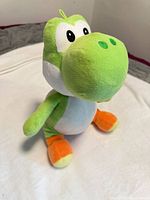 Front view of green Yoshi plush showing overall appearance and colors