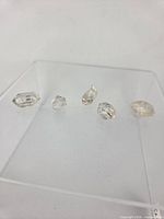 five clear double-terminated quartz crystals