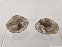 Both quartz geode halves displayed upright to show crystal interiors
