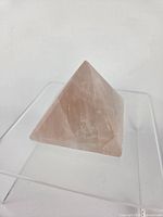 Rose quartz pyramid side view showing translucent pink stone and polished facets