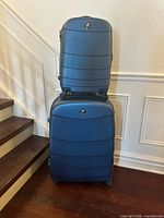 Stacked blue hard shell suitcases showing size difference and exterior condition
