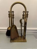 Full view of brass stand with three hanging tools
