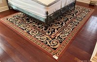Full view of wool rug under bed showing size, pattern and colours