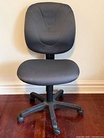 Front view of black office swivel chair showing seat, backrest, and wheeled base