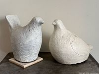 Front view of both cement bird sculptures