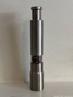 Full view of stainless steel pepper grinder standing upright