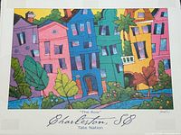 Full view of framed poster showing colourful houses and title/artist credit