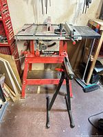 Table saw on stand with roller stand visible