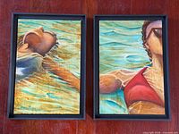 Both framed swimmer paintings side by side