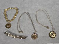 Group view of all jewelry pieces laid out: brooch, two necklaces, bracelet