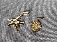 Overview of both 10K gold pendants on fabric background