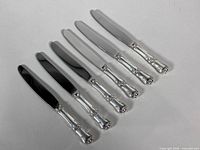 Six knives laid flat showing complete set