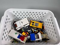 Loose LEGO vehicles and bricks inside white perforated bin