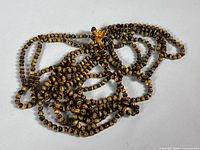Entire coiled strand of tiger's eye beads showing length and clasp