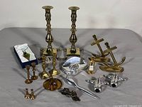 Entire lot overview showing brass candlesticks, anchor bookends, Hoselton aluminum pieces, Linden clock, magnifier, miniature candlesticks, mineral box