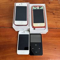 Overview of two boxed iPhones, one loose white iPhone, black iPod