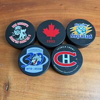 Group of five commemorative hockey pucks