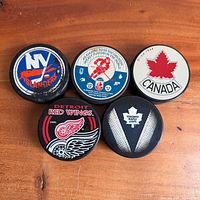 Group shot of five NHL hockey pucks