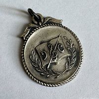 Front view of sterling pendant showing music book, clef, laurel and rope edge design