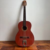 Front view of Suzuki acoustic guitar showing overall design, trapeze tailpiece and wear