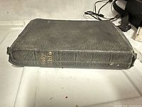 Closed Bible showing black pebbled leather cover and gilt spine title