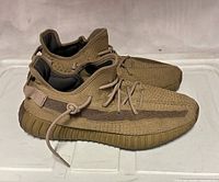 Right lateral view of both Adidas Boost 779001 sneakers showing knit upper, sole and lacing