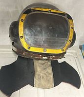 Front view of diving helmet showing faceplate, hardware, neck dam